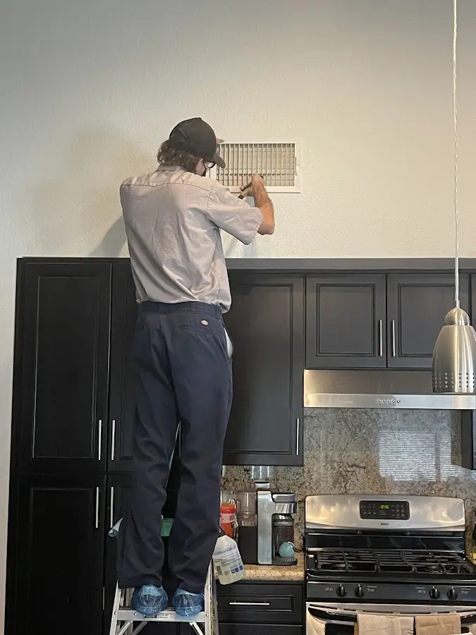 Technician inspecting an air vent during HVAC service in Moncks Corner
